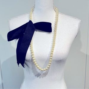 Long pearl necklace with black ribbon bow